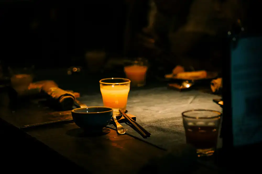 Guests laughing and sharing a meal around a dimly lit table